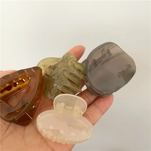 Set of four geometric triangular hair claws in various translucent colors and patterns
