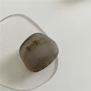 Detailed close-up of a translucent amber geometric hair claw clip with metallic spring