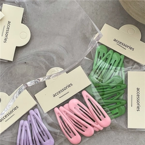 Détail de barrettes à cheveux mates macaron en vert, rose et violet avec support carton