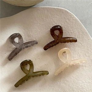 Detailed close-up of colorful jelly-textured hair claws on a textured stone tray