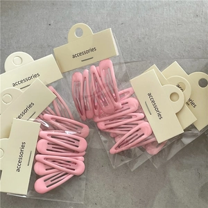 Détail des barrettes à cheveux en métal rose macaron sur cartes de présentation pour coiffure