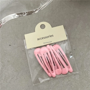 Détail de pinces à cheveux roses en forme de goutte avec emballage cartonné