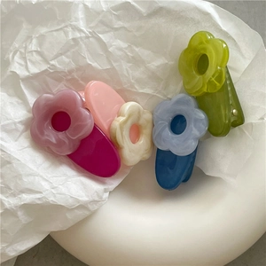 Detail of colorful acetate flower hair clips with marble texture and duckbill design