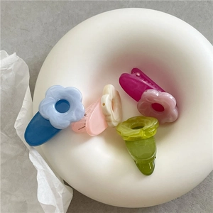 Close-up of colorful matte resin flower hair clips in a stylish gift display tray