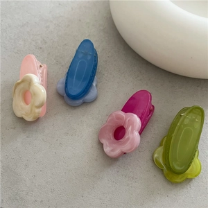 Close-up of four colorful acetate flower hair clips with marble texture for styling