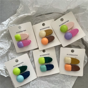 Détail des barrettes géométriques colorées sur carton blanc avec texte accessories