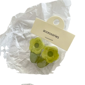Pair of cute light green flower hair clips with matte resin finish on display card
