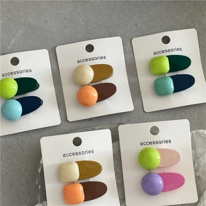 Gros plan de pinces à cheveux géométriques colorées aux nuances bonbon sur carte