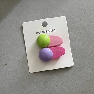 Détail de barrettes géométriques en résine colorée aux tons pastel vert, rose et mauve