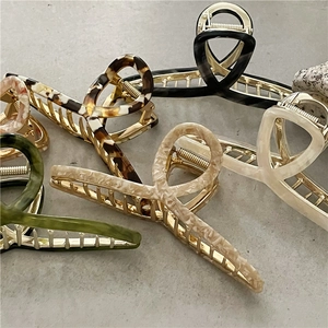 Detail showing various colors of large acetate shark hair clips with cross-tooth design