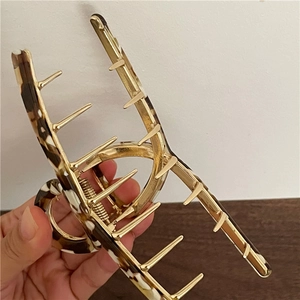 Detail showing a 14cm acetate alloy hair claw clip with elegant tortoiseshell texture
