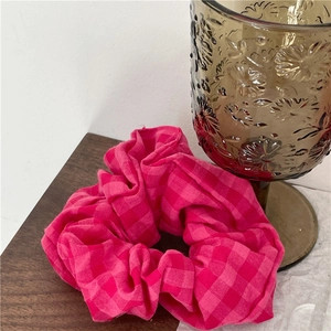 Chouchou à carreaux roses avec texture de tissu plissé sur une table en bois