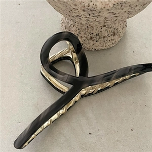 Detail of 14cm acetate shark hair claw with dark grey marble pattern and gold metal spring
