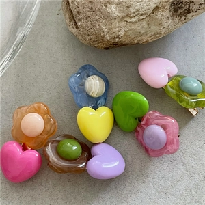 Set di fermagli per capelli in resina colorata a fiori e cuori su sfondo di pietra