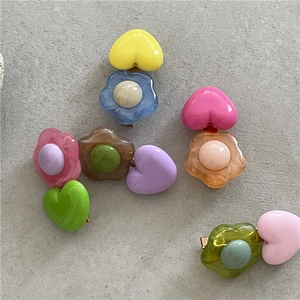 Dettaglio di fermagli per capelli colorati a fiori in resina con perle e clip a becco d'anatra