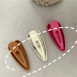 Three matte alloy BB hair clips in brown, beige, and rose red colors set on grey background
