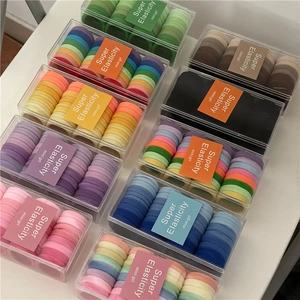 Vista dall'alto di set di elastici per capelli colorati in scatole trasparenti con vari toni