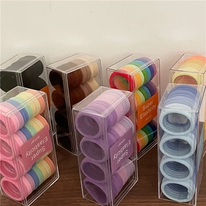 Dettaglio di elastici per capelli colorati in scatole di plastica trasparenti