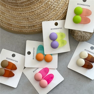 Detail of candy-colored matte and translucent hair clips on a white accessory card