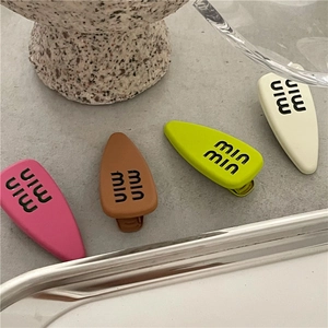 Set of 4 matte rubberized alloy hair clips in pink, brown, lime, and cream with logo