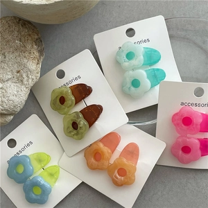 Detail of colorful resin floral hair clips in jelly texture on a card display