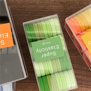 Set di mini elastici per capelli colorati ad alta elasticità in scatola su fondo legno