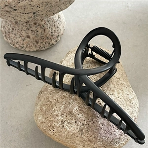 Close-up of minimalist matte black hair claw clip with sturdy metal spring mechanism
