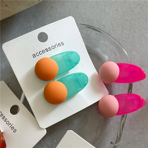 Detail showing candy-colored matte ball hair clips set in orange and pink jelly texture