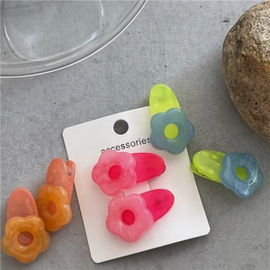 Detailed macro of jelly-like flower hair clips with marble texture on display card