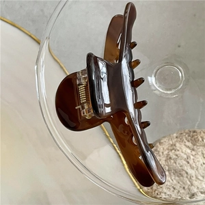 Close-up of tortoise shell pattern acetate hair claw clip with golden metal spring