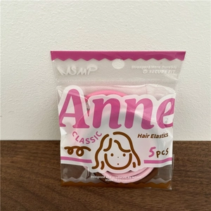 Detail of pink and brown seamless hair elastics in 5-piece packaging on a wood desk