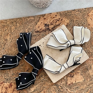Elegant large bow hair clips with pearls and contrast stitching on textured fabric