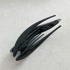 Close-up of glossy black crescent hair claw clip with internal teeth and sleek finish