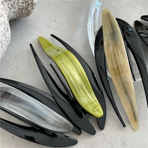 Detailed macro view of four stylish acetate hair claws in marble and solid color textures