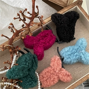 Fuzzy faux shearling claw clips set in five colors on a rustic wooden tray decoration