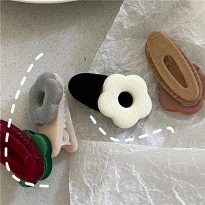 Detailed macro view of soft flocked flower hair clips in various winter colors and textures