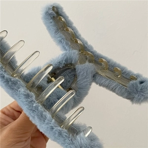 Détail d'une pince à cheveux en fausse fourrure bleu clair avec dents en plastique