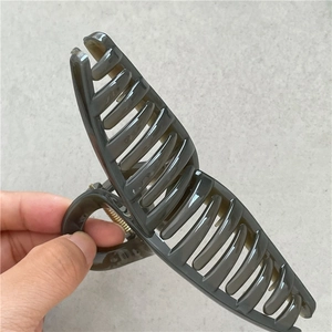 Macro detail of large translucent olive green hair claw clip with multi-teeth design