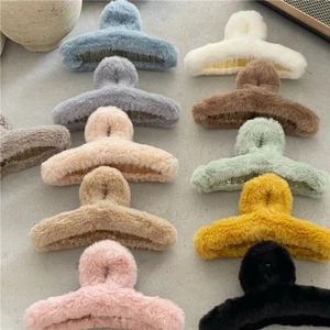 Vue détaillée de pinces à cheveux en fausse fourrure douce colorée sur fond texturé