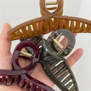 Detail of large jelly texture hair claws in amber, burgundy and black with gold springs