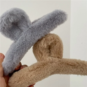 Détail de la pince à cheveux en fausse fourrure grise et kaki pour coiffures d'hiver
