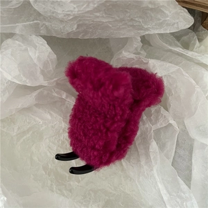 Detailed view of the soft rose red faux lamb wool plush hair claw with black plastic teeth