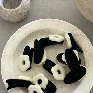 Cute black and white flocked flower hair clips in a minimalist aesthetic stone tray