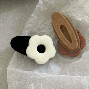 Detailed view of flocked flower hair clips with soft matte texture and cute petal design