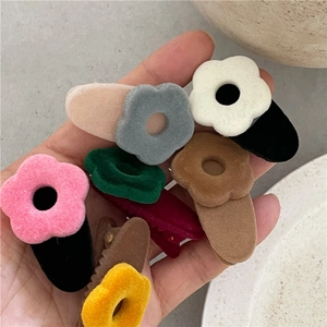Close-up of colorful flocked flower hair clips with a soft velvet texture for women