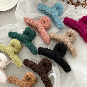 Fuzzy faux shearling hair claw clips in assorted autumn colors on a soft white fabric