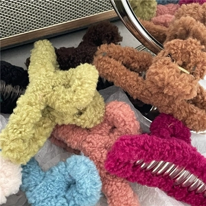 Close-up of assorted plush faux fur hair claw clips in vibrant winter colors