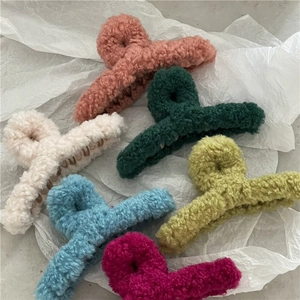 Detailed view of plush faux fur hair claw clips in various soft pastel colors