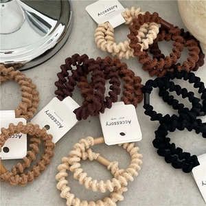 Set di elastici per capelli a costine dai toni neutri su superficie minimalista moderna