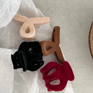 Vista dettagliata di quattro mini mollette per capelli floccate in beige, marrone e nero